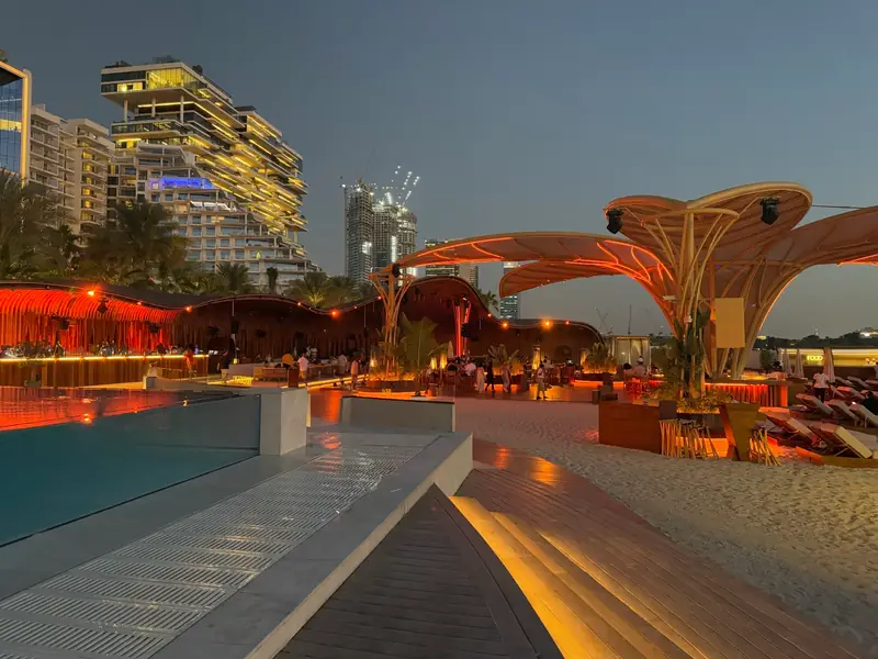 A palm-lined Dubai pool terrace lit at dusk